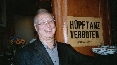 Sigmar Polke vor einem Schild mit der Aufschrift 